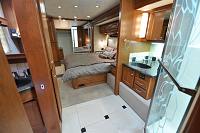 The oversize bathroom with a large hexagonal shower, double sinks and commode with exceptional cabinet space